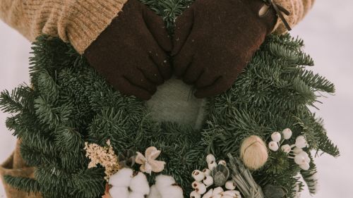 Hands touching Christmas wreath HD Wallpaper