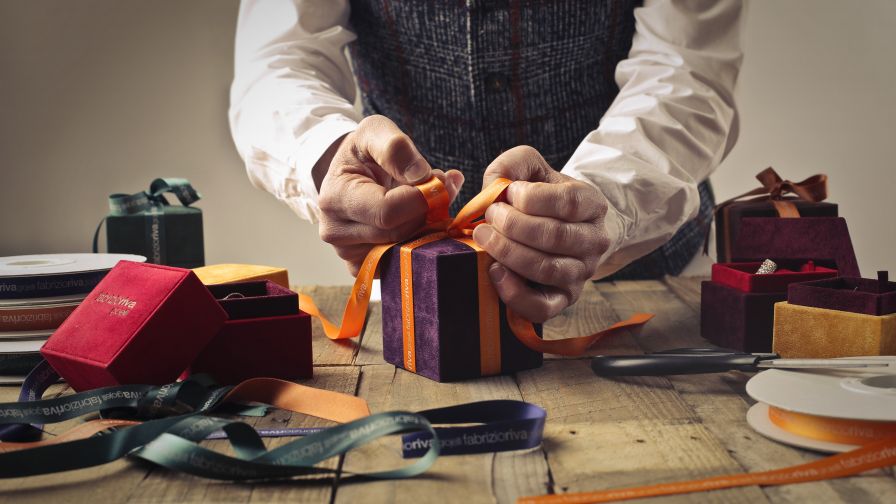 Person Tying Ribbon on Purple Gift Box HD Wallpaper